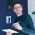 A man wearing glases and holding a pen is smiling at the came. He is Sander Kooi, Online Marketer at Convident